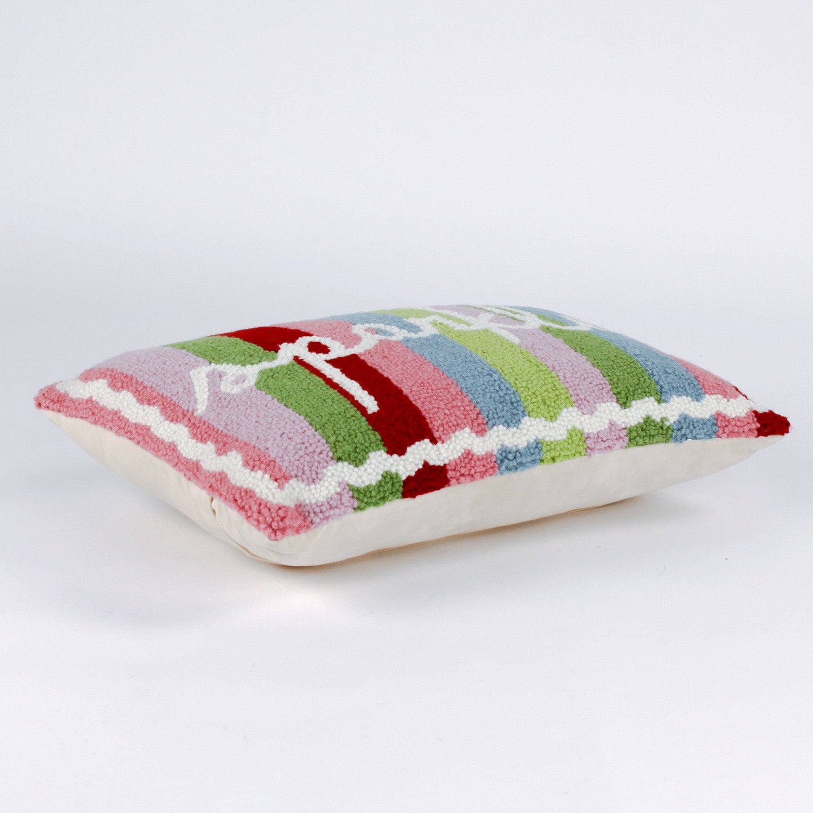 side of a Rectangular pillow with colorful vertical stripes in red, pink, green, blue, and lavender, featuring the word “sparkle” written in white cursive with a small gold star above the letter “k.”