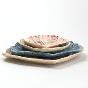 A collection of 4 nested ceramic shell bowls in graduating sizes from madcap cottage