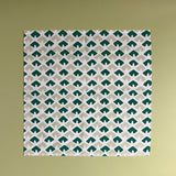 a white and green dinner napkin featuring a triangular block print motif called Old Jaipur from Madcap Cottage. 