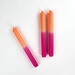 three pink and orange taper candles