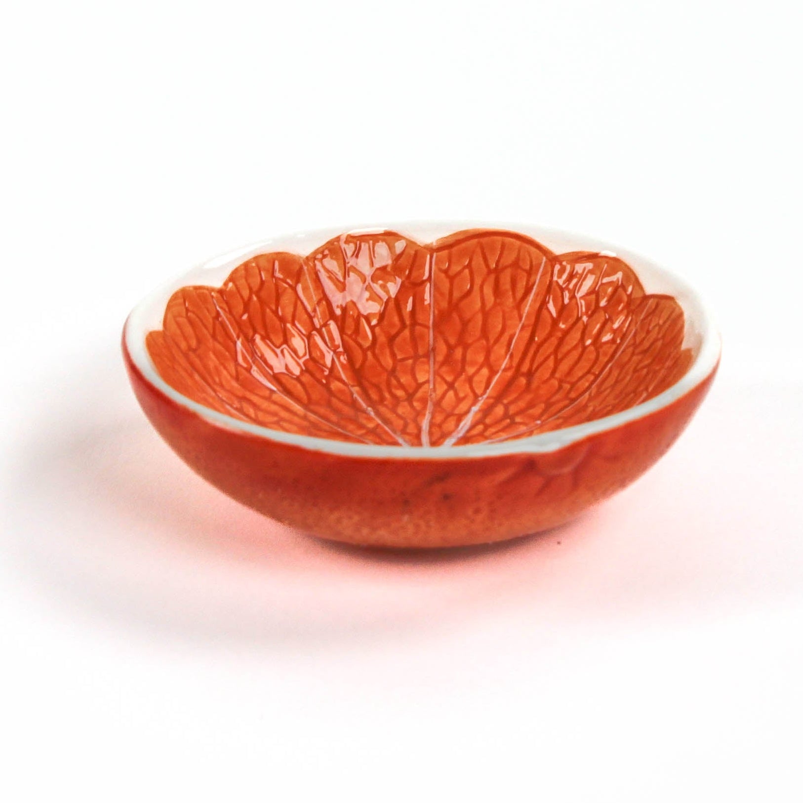 orange ceramic bowl resembling orange citrus fruit  on a white background