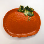 a large orange pumpkin serving platter against a white background