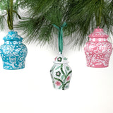 Set of three hand-painted ginger jar Christmas ornaments in blue, green, and pink hanging from pine branches, chinoiserie holiday decor.