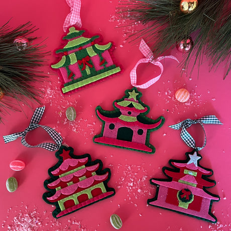 four pink felt chinoiserie christmas ornaments in the shape of pagodas against a red background 