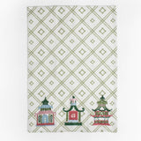 a green and white chinoiserie tea towel with three embroidered pagoda motifs. 