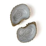 Two ceramic oyster shells with shellfish on a white background