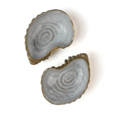 Two ceramic oyster shells with shellfish on a white background