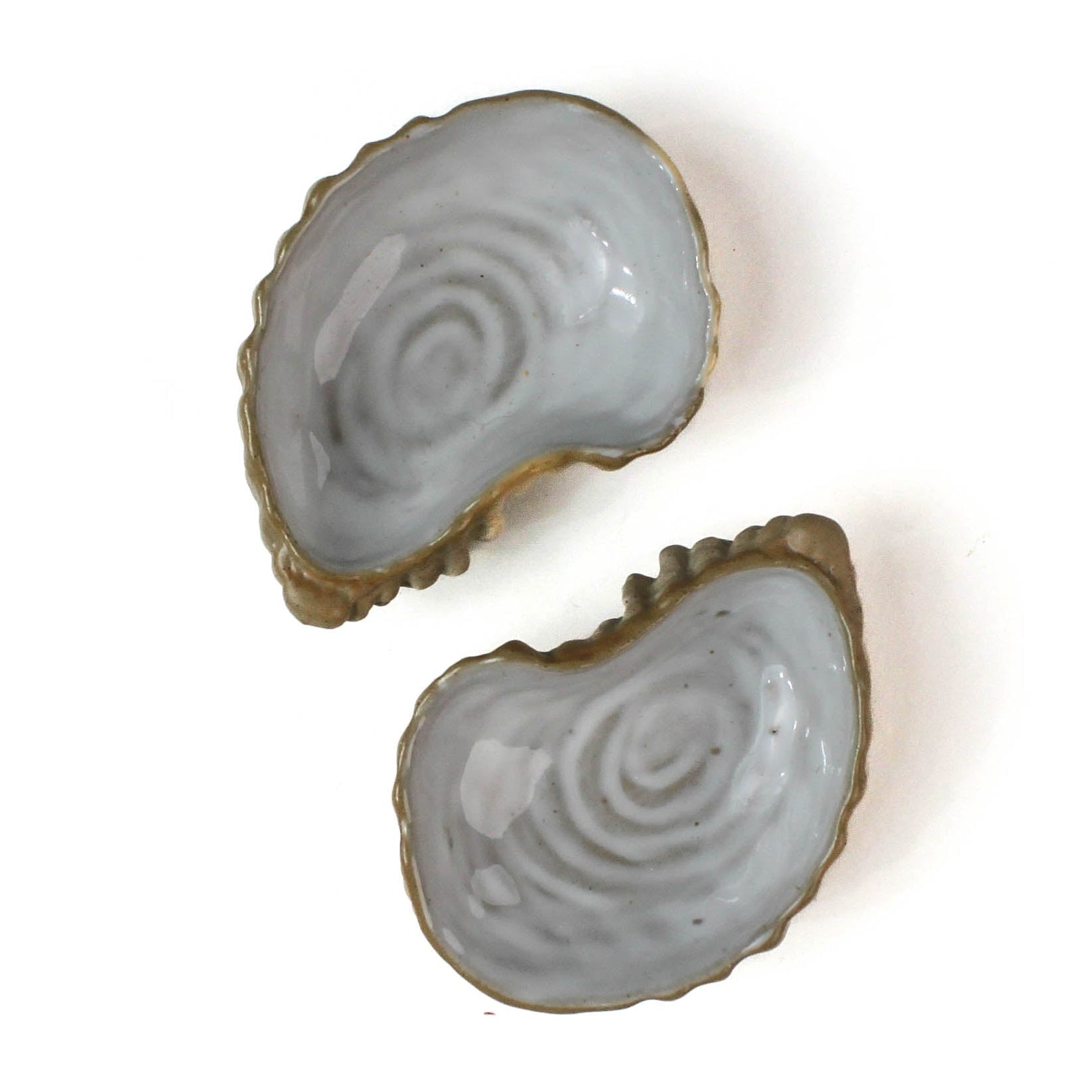 Two ceramic oyster shells with shellfish on a white background