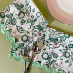chinese dragon chinoiserie dinner napkins with pink china plate and silverware on a green background