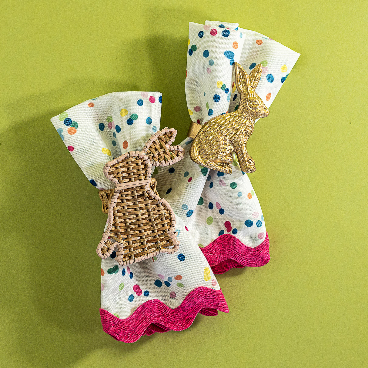 A pair of Springtime confetti multicolor cloth dinner napkins from Madcap Cottage with ric rac trim on a light green background.