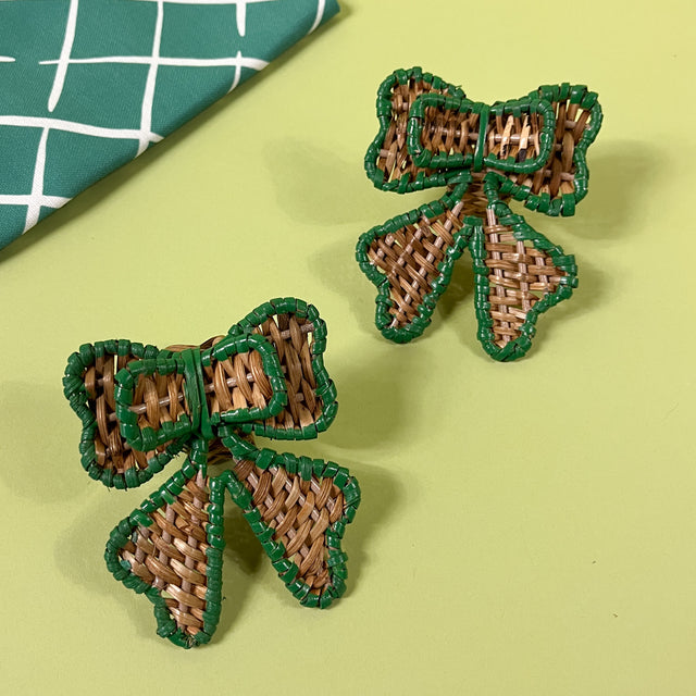 pair of green rattan bow napkin rings with napkin