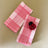 a pair of pink gingham dinner napkins in gin lane print fabric by madap cottage with a small lady bug dish resting on the top of one napkin