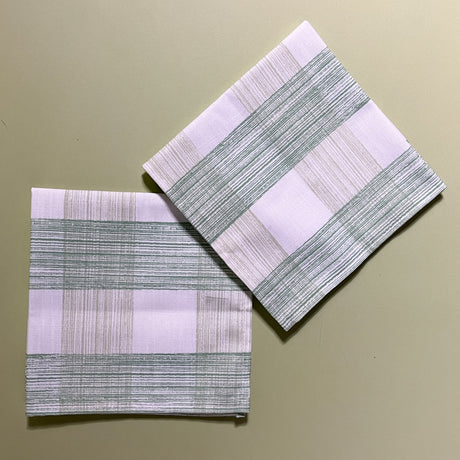 two green gingham dinner napkins in gin lane print fabric by madap cottage on a light green background