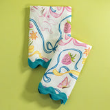 A pair of Bunnies and bow print fabric easter napkins in multicolor against a light green background. 