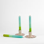 blue and green taper candles in white scalloped candle holders