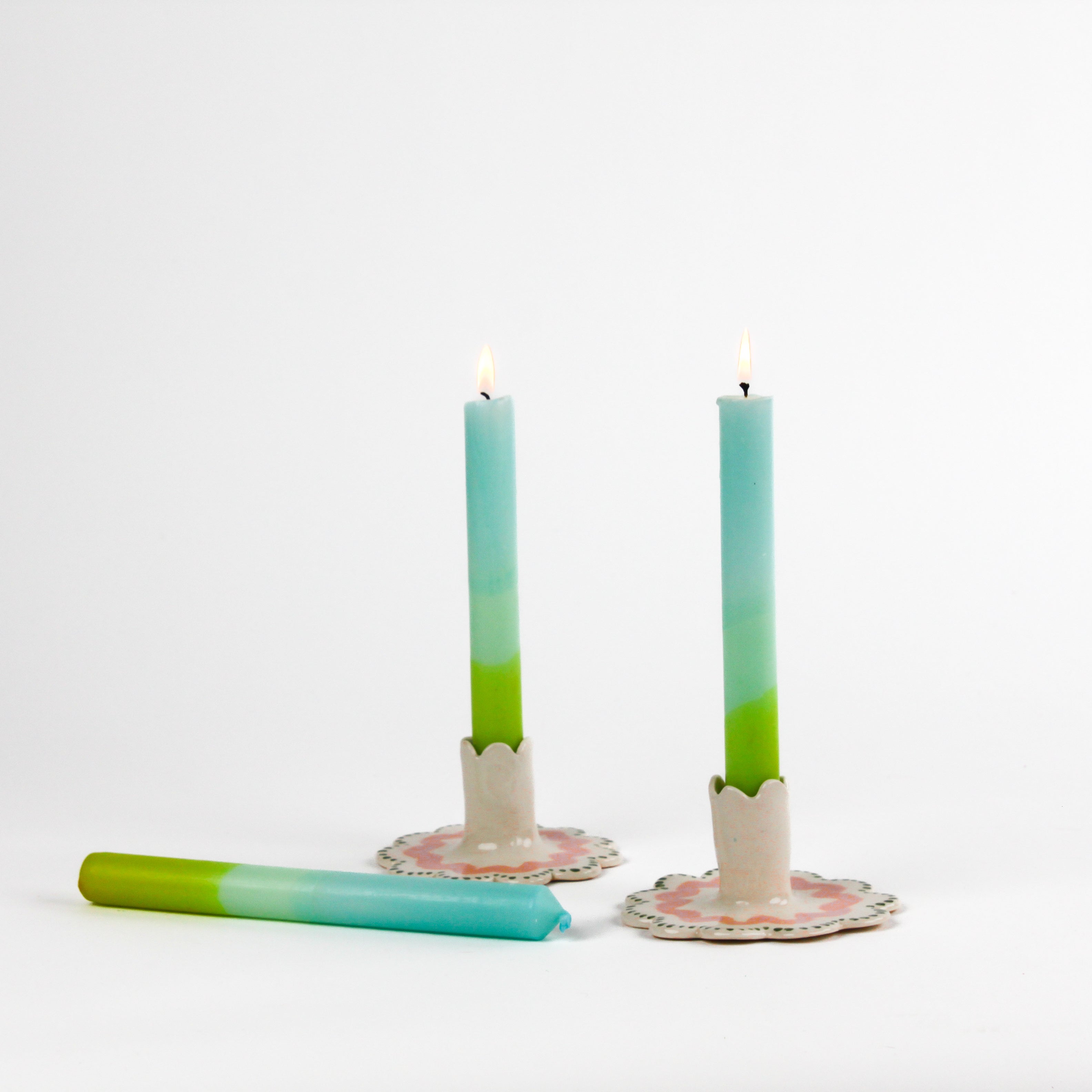 blue and green taper candles in white scalloped candle holders