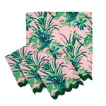 Set of palm leaf print napkins with lush green tropical foliage on a soft pink background and scalloped edge, stylish table linens perfect for Christmas tea towel styling, holiday entertaining, and seasonal home décor