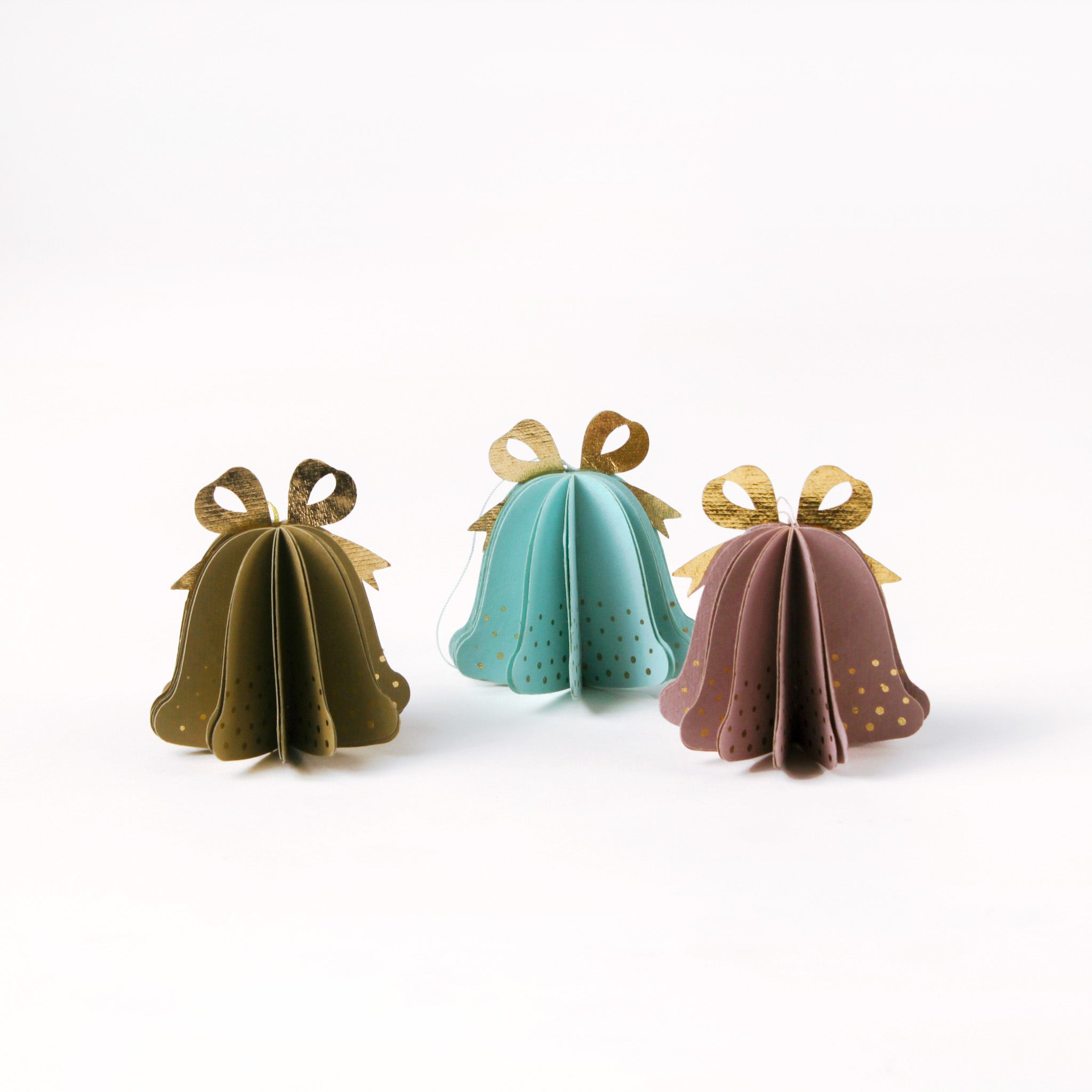 Set of pastel paper Christmas bell ornaments in blue, brown, and pink, featuring metallic gold bows and dotted details