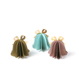 Set of pastel paper Christmas bell ornaments in blue, brown, and pink, featuring metallic gold bows and dotted details