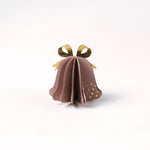 Single pastel paper Christmas bell ornaments in pink with metallic gold bows and dotted accents