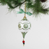 paper mache green star christmas ornament hanging in a branch