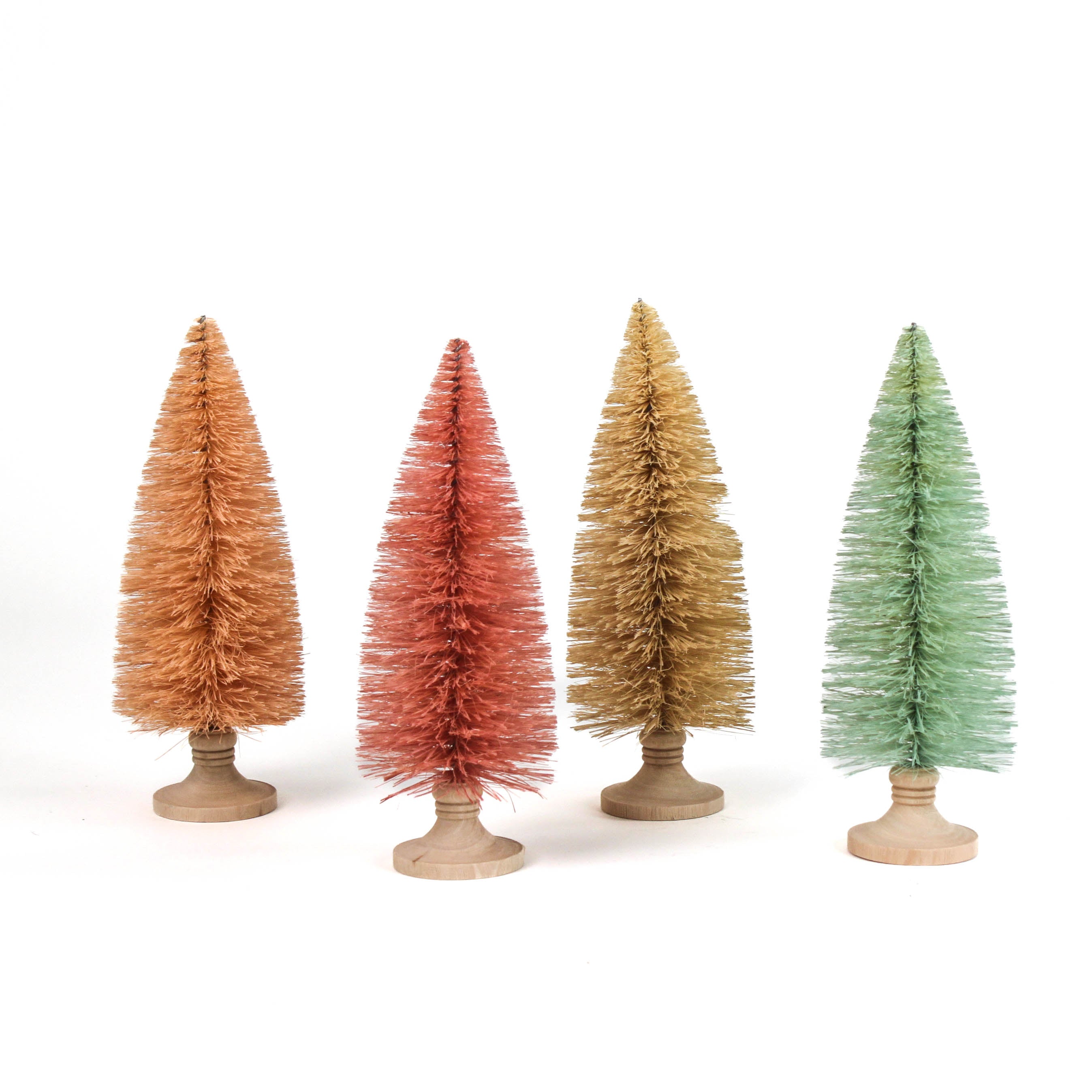 Four miniature bottle brush Christmas trees table decorations in light pink, pink, green and beige on a white background.