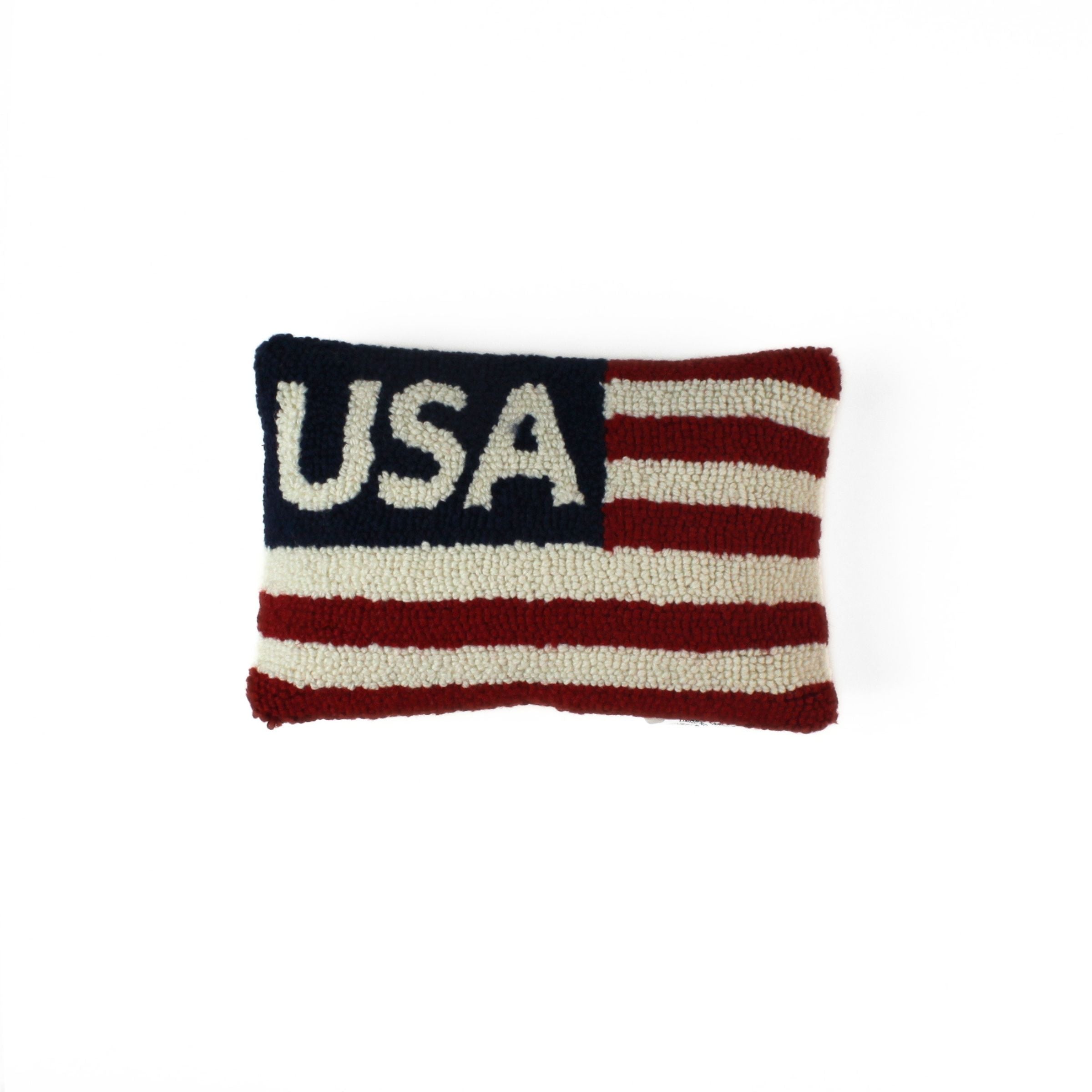 a patriotic USA pillow with red and white stripes and blue and white text that reads USA in the upper left corner on a white background