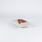 side of a Rectangular decorative pillow with a design of a jockey outfit in pink and green, featuring polka dots on the shirt and a matching pink riding cap on a cream background.