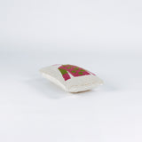 side of a Rectangular decorative pillow with a design of a jockey outfit in pink and green, featuring polka dots on the shirt and a matching pink riding cap on a cream background.