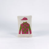 Rectangular decorative pillow with a design of a jockey outfit in pink and green, featuring polka dots on the shirt and a matching pink riding cap on a cream background.