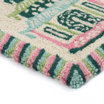 close up details of A rectangular pink and green rug with a trio of pagodas in the centre and a green striped border