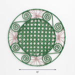 Round pink and green rattan placemat with pink woven accents and spiral details, 15 inch diameter