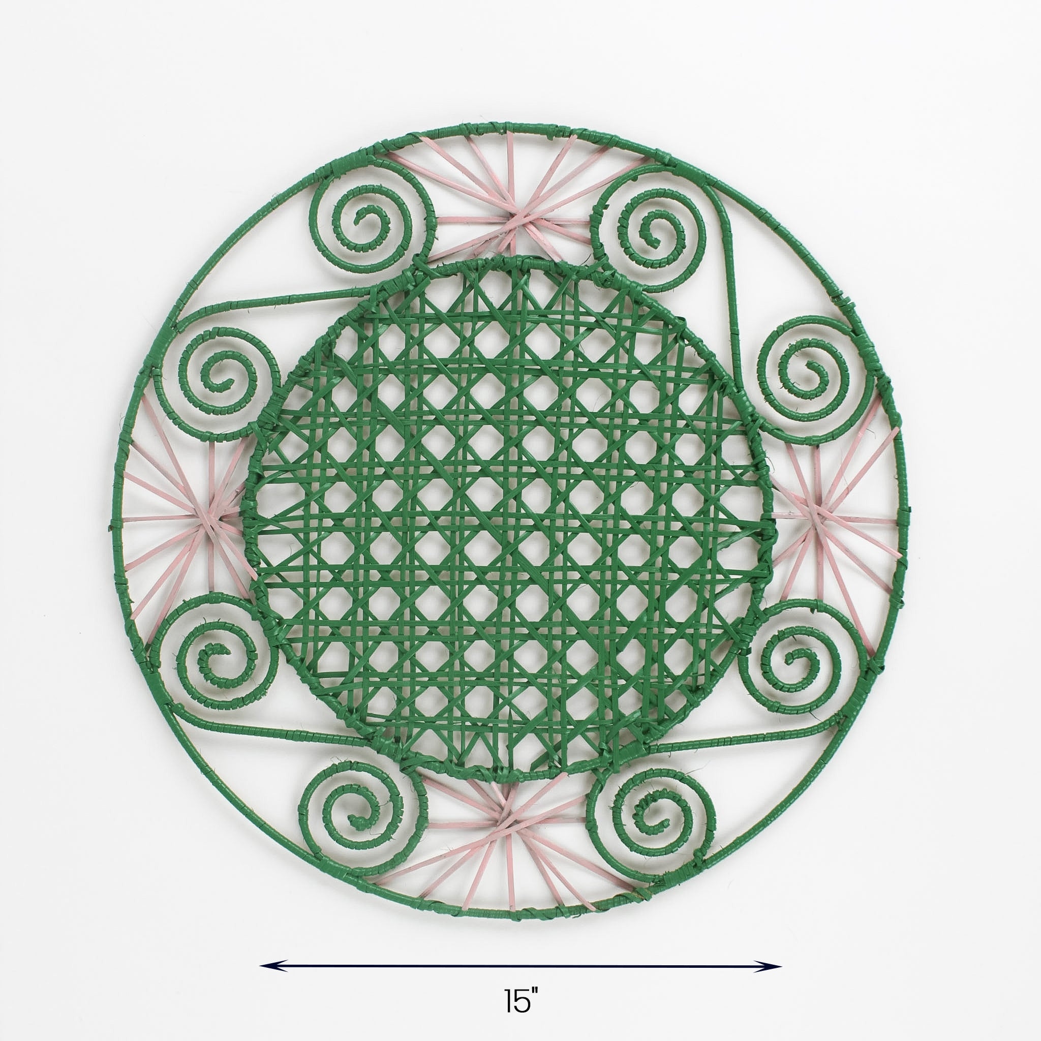 Round pink and green rattan placemat with pink woven accents and spiral details, 15 inch diameter