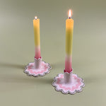 A pair pastel taper candles in Scalloped ceramic candle holders with a pink and green wavy motif in the Harbor Trail pattern
