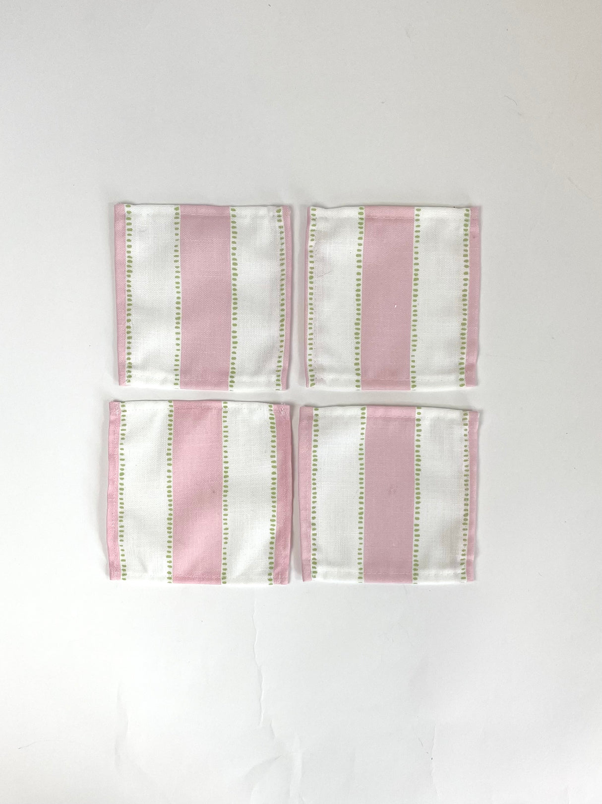 A set of four cotton white and pink stripe coasters in cabana boy print from madcap cottage