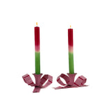 set of pink bow shaped candle holders with green and red canles and a glossy finish on white background