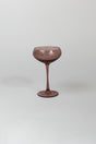 a pink coupe glass on a white background