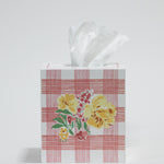 a pink gingham tissue box cover with a central yellow floral motif on the front. 
