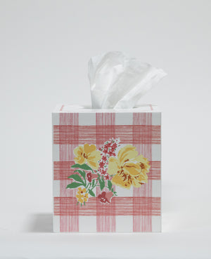 a pink gingham tissue box cover with a central yellow floral motif on the front. 