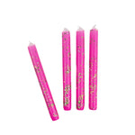 Pink glitter taper candles with green and gold confetti-style sparkle detailing for festive table decor.