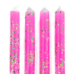 Pink glitter taper candles with green and gold confetti-style sparkle detailing for festive table decor.