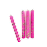 Pink glitter taper candles with green and gold confetti-style sparkle detailing for festive table decor.