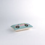 side of a Rectangular decorative pillow with a design of a pink golf cart featuring green seats, a blue golf bag, and a pink-and-white canopy on a light blue background.