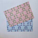 pink and green bamboo lattice paper placemats layered on white background