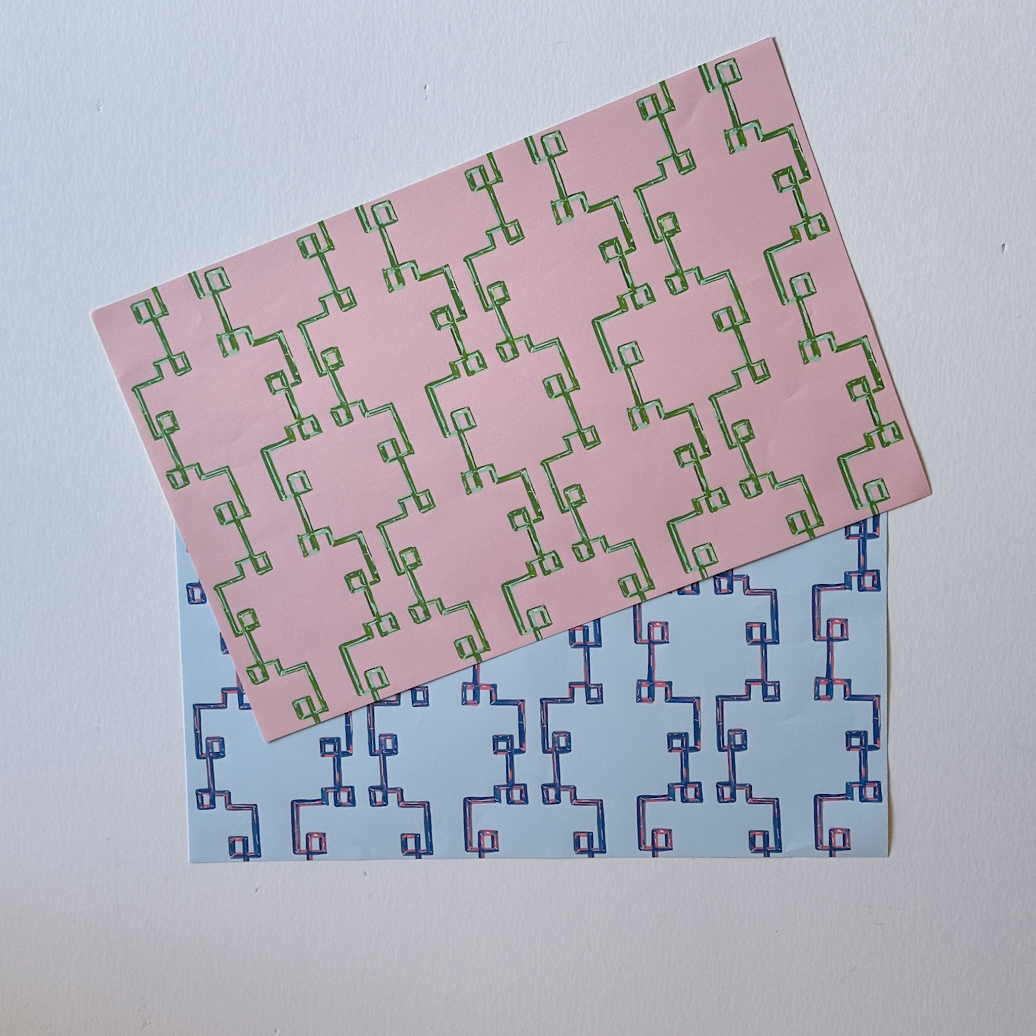 pink and green bamboo lattice paper placemats layered on white background