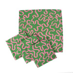 Set of green napkins with playful pink squiggle pattern arranged on a white background, modern table linens perfect for Christmas tea towel styling, holiday entertaining, and seasonal home décor