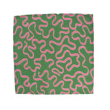 Green napkin with playful pink squiggle pattern on a white background, modern table linen perfect for Christmas tea towel styling, holiday entertaining, and seasonal home décor