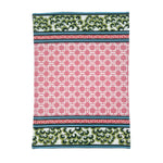 A pink and green chinoiserie tea towel featuring a central pink lattice pattern and green floral border against a white background. 