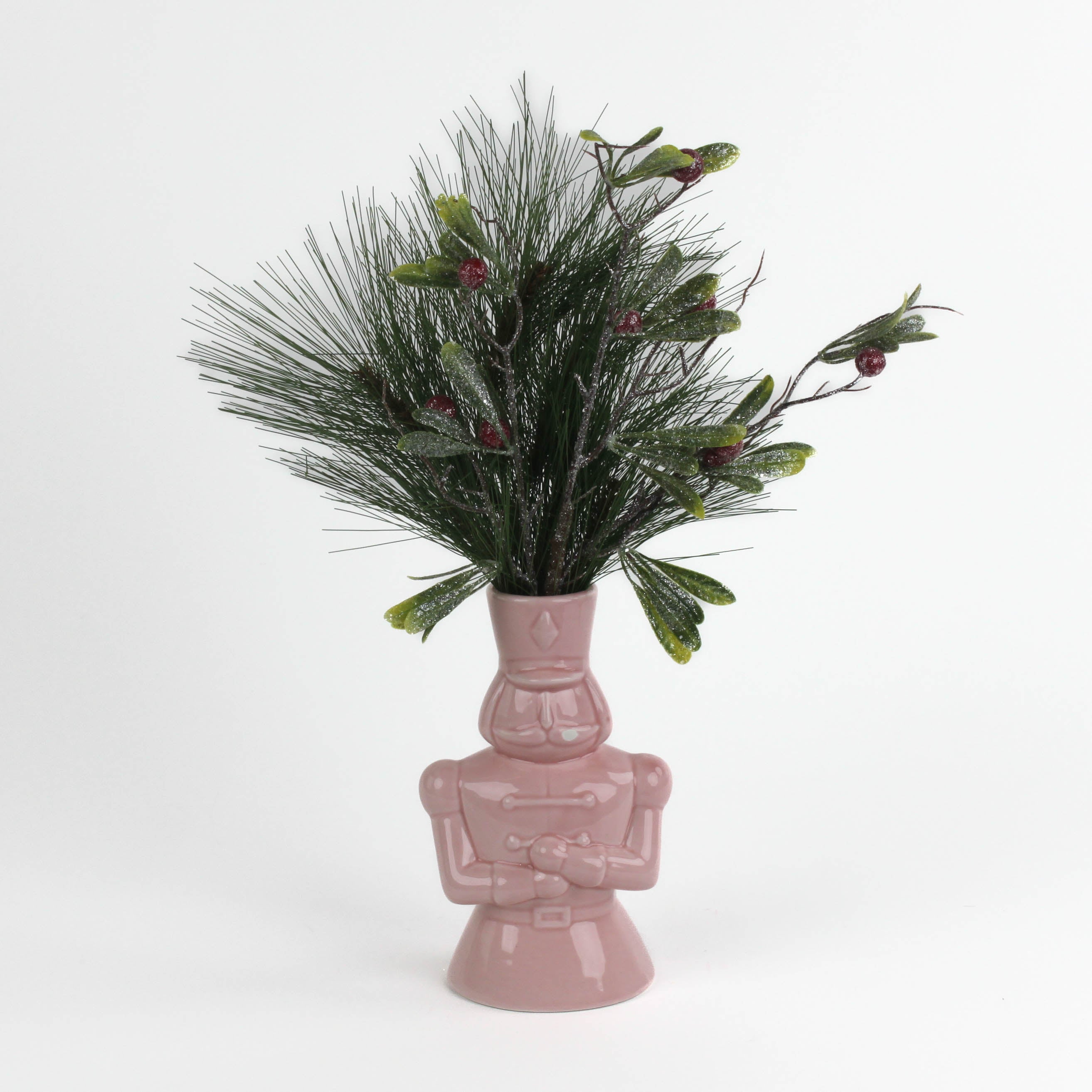 Pink nutcracker vase filled with greenery on a white background