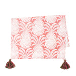 a white and pink pineapple tea towel with pink and green tassels against a white background. 